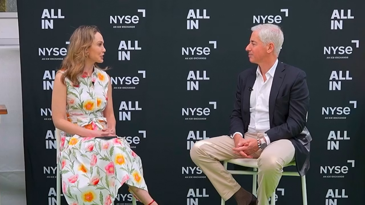 two people sitting down and speaking at a conference