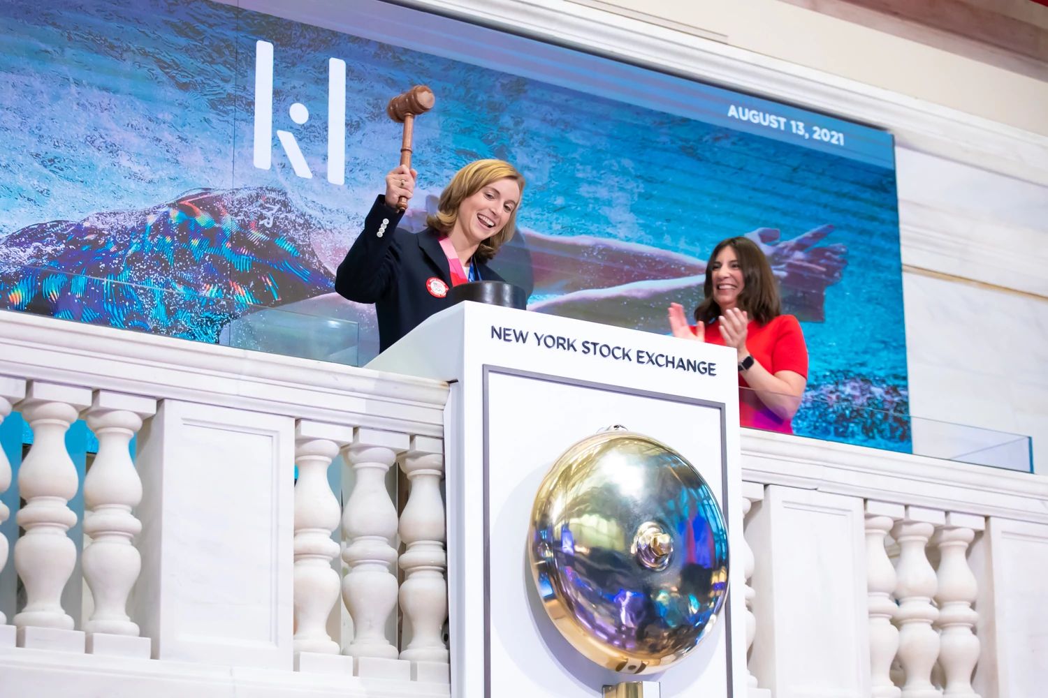 Katie Ledecky strikes the gavel after ringing the closing bell.