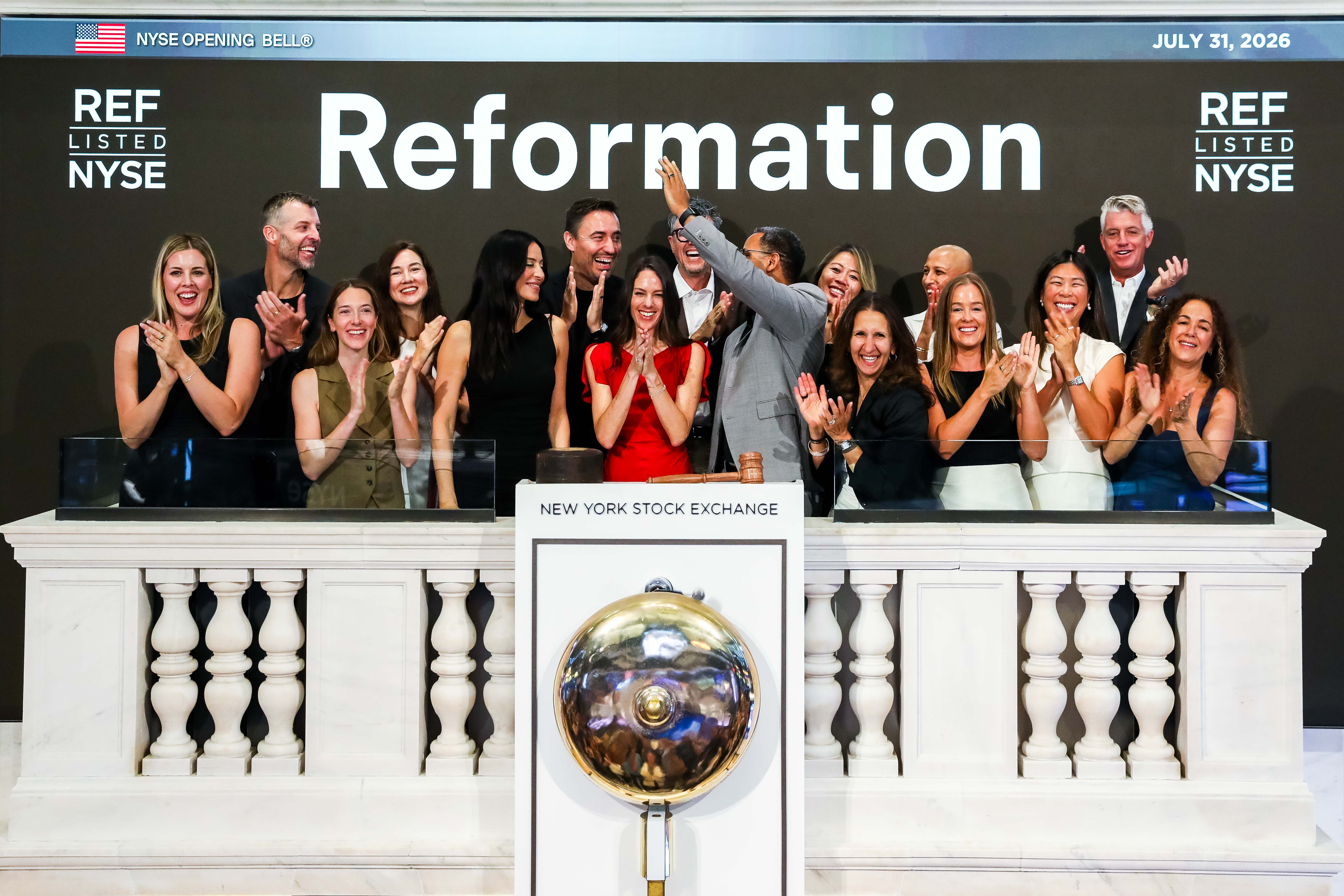 Reformation team members cheer and applaud on the NYSE bell-ringing balcony on July 31, 2026, beneath a backdrop reading "Reformation" and "REF Listed NYSE."